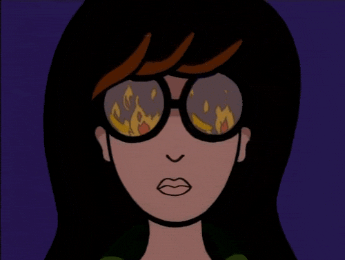 An image of Dario from the MTV cartoon. she has brown hair and glasses and a blank expression and you can't see her eyes, but reflected in her glasses are flames burning higher