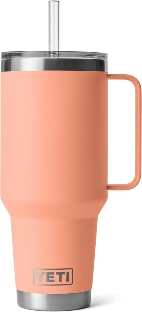 A peach metal tumbler with drinking straw