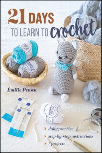 21 Days to Learn to Crochet by Emilie Penou - daily practice step by step instructions, and 7 projects. Pictured on the cover is a doll shaped like a cat, some skeins of yarn, and crochet hooks