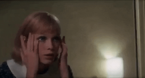 Mia Farrow in Rosemary's Baby, looking at something in a happy and excited way
