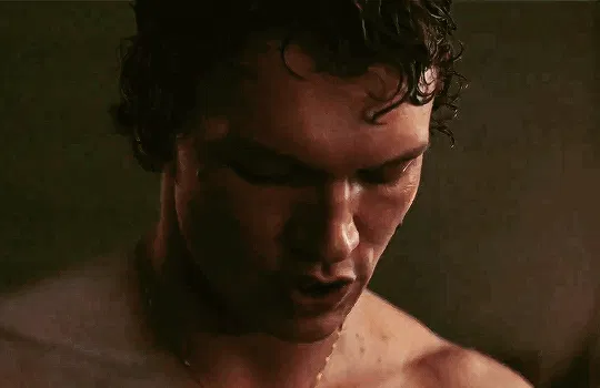 Ilya is sweaty and shirtless and looks up after saying something