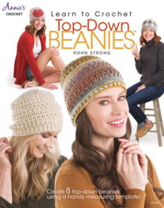 Learn to Crochet Top-Down Beanies by Rohn Strong from Annie's Crochet. Four white women wearing four different crochet beanies in shades of brown, gold, white, and blue