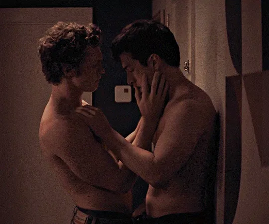 Shirtless Ilya holds shirtless shane against a wall, then slowly presses his thumb into Shane's mouth