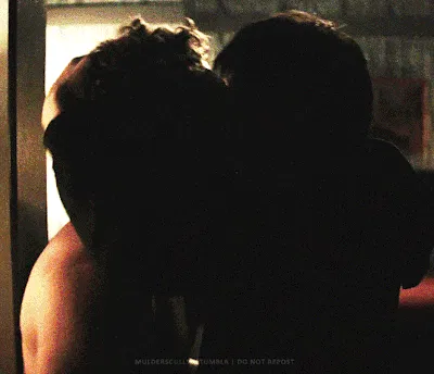 Shirtless Ilya picks up Shane and starts to carry him toward the bed