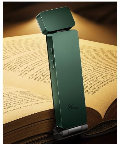 A dark green book lamp with a tilted head shining gold light onto a book