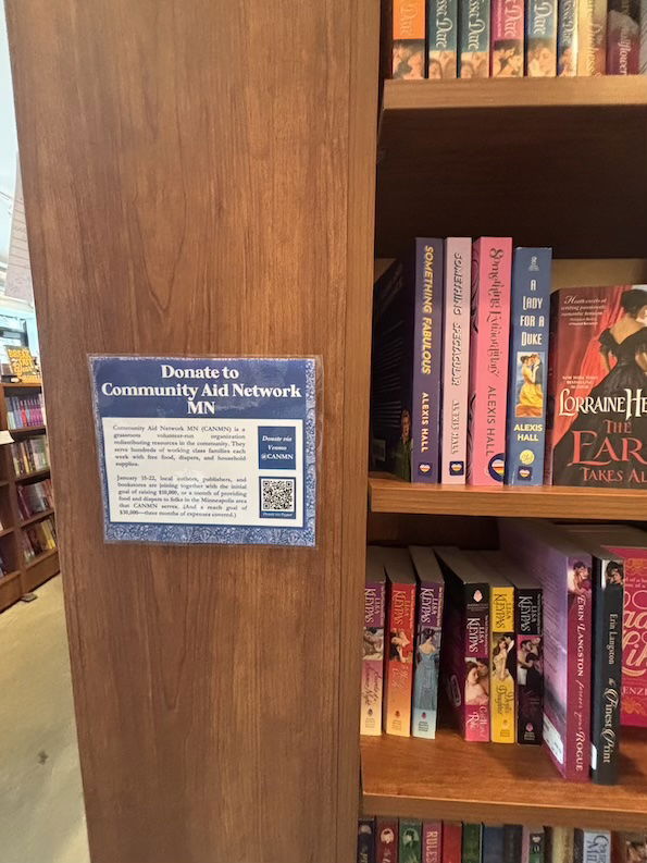 A laminated sign with a QR code that says Donate to Community Aid Network MN 