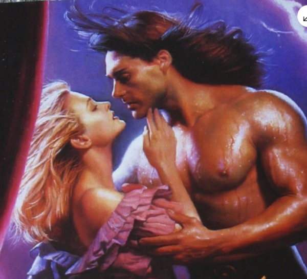 Close up of a cover with John DeSalvo's hair blowing backwards at a high velocity. DeSalvo is shirtless and covered with something drippy, wet, and shiny.