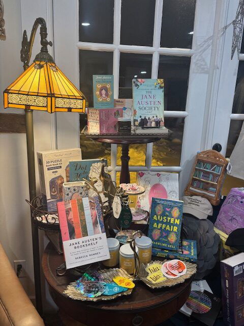 A table with a vintage lamp over a display of books and merch