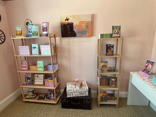 Cowboy art above some bookshelves with cowboy books displated