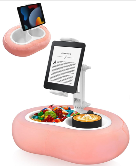 A pink lap stand for an ereader or tablet with a white plastic arm and a pink base with large compartments for candy and a beverage 