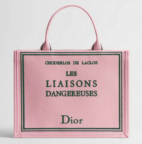 A pink woven tote with Choderlos de Laclos, Les Liaisons Dangereuses embroidered in green on pink, with Dior at the bottom