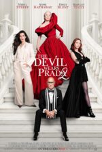 The Devil Wears Prada 2 - the four leads standing on a white staircase. Anne Hathaway has long brown hair and is in a white suit, Emily Blunt is in a black dress looking down at the viewer, Meryl Streep is in a giant red gown swanning at the top while Stanley Tucci is in a tux seated at the bottom