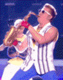 A man in a striped vest and blue trousers plays the sax and rocks up and down sped up