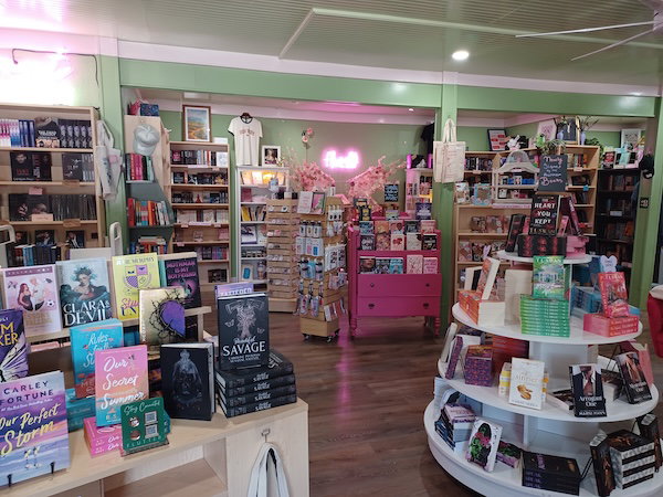 another interior shot with lime green walls, pink furniture, and books displayed on tables and round tiered cases