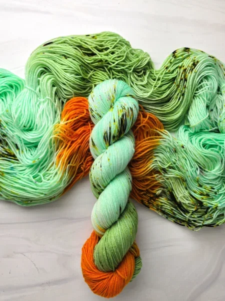 Mint green and orange yarn with black speckles