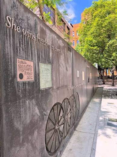 The memorial park showing green trees and a portion of the memorial wall