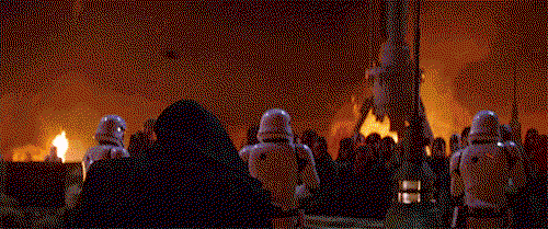 a close up of kylo ren with his black mask on, reaching one hand toward the camera while holding a red lightsaber