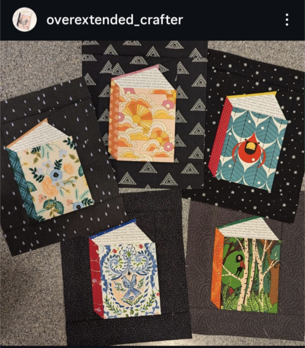 A close up of five quilt blocks, each depicting a book standing upright with pages played open in a V. The covers of the books are all printed fabrics, and the pages of the books are the same fabric with lines of text printed on it.